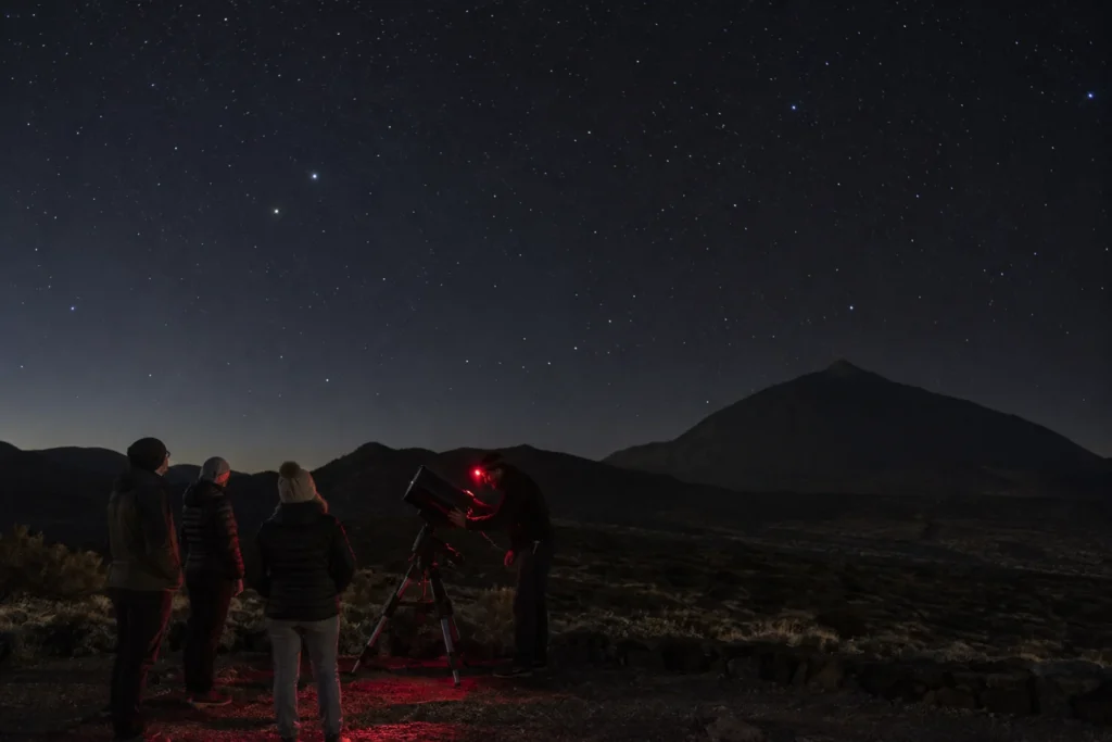 Observación astronómica con telescopio y luz roja bajo el cielo del Teide